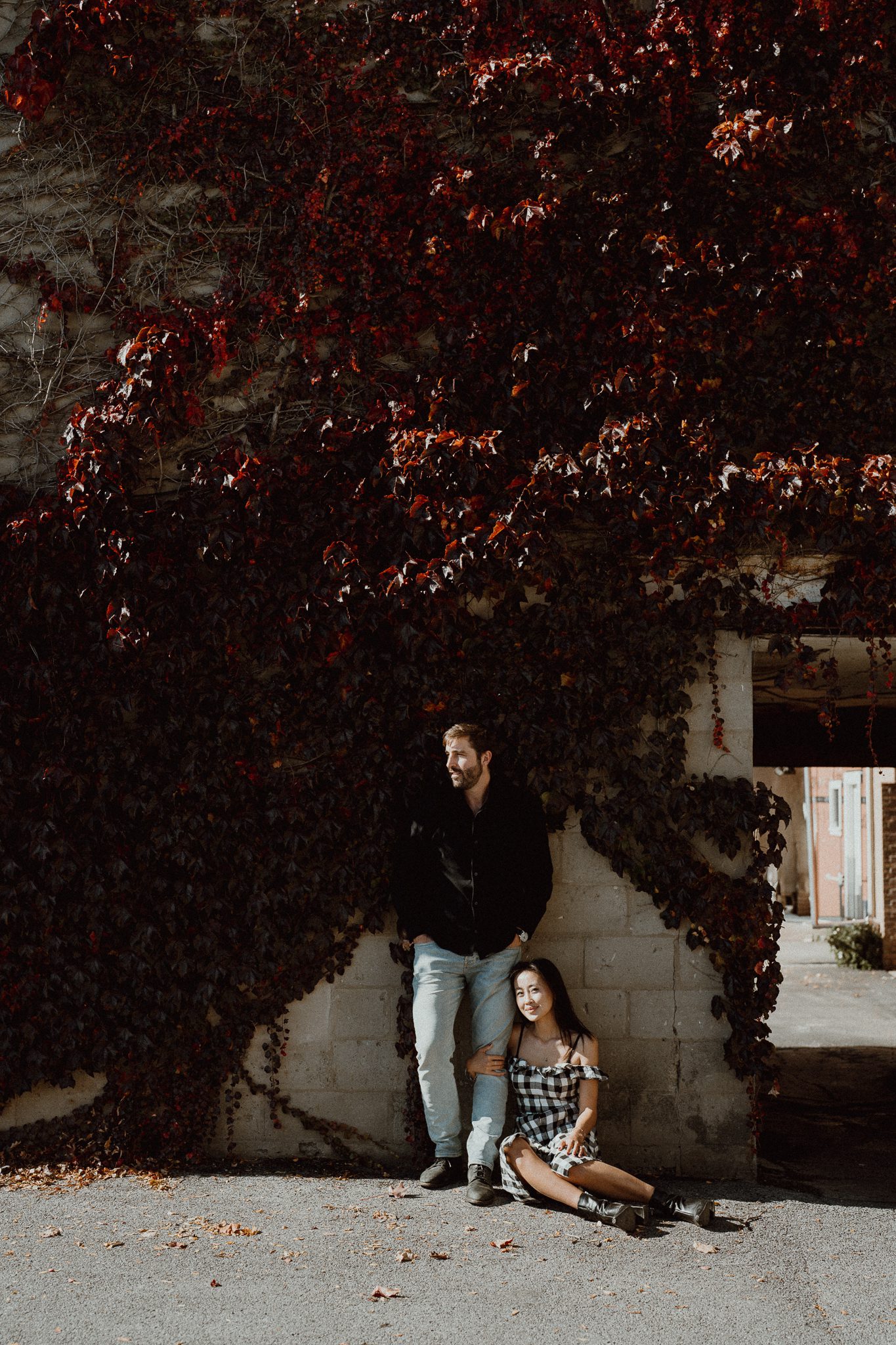 Couple sitting close together on a wooden dock on Skaneateles Lake during their engagement session