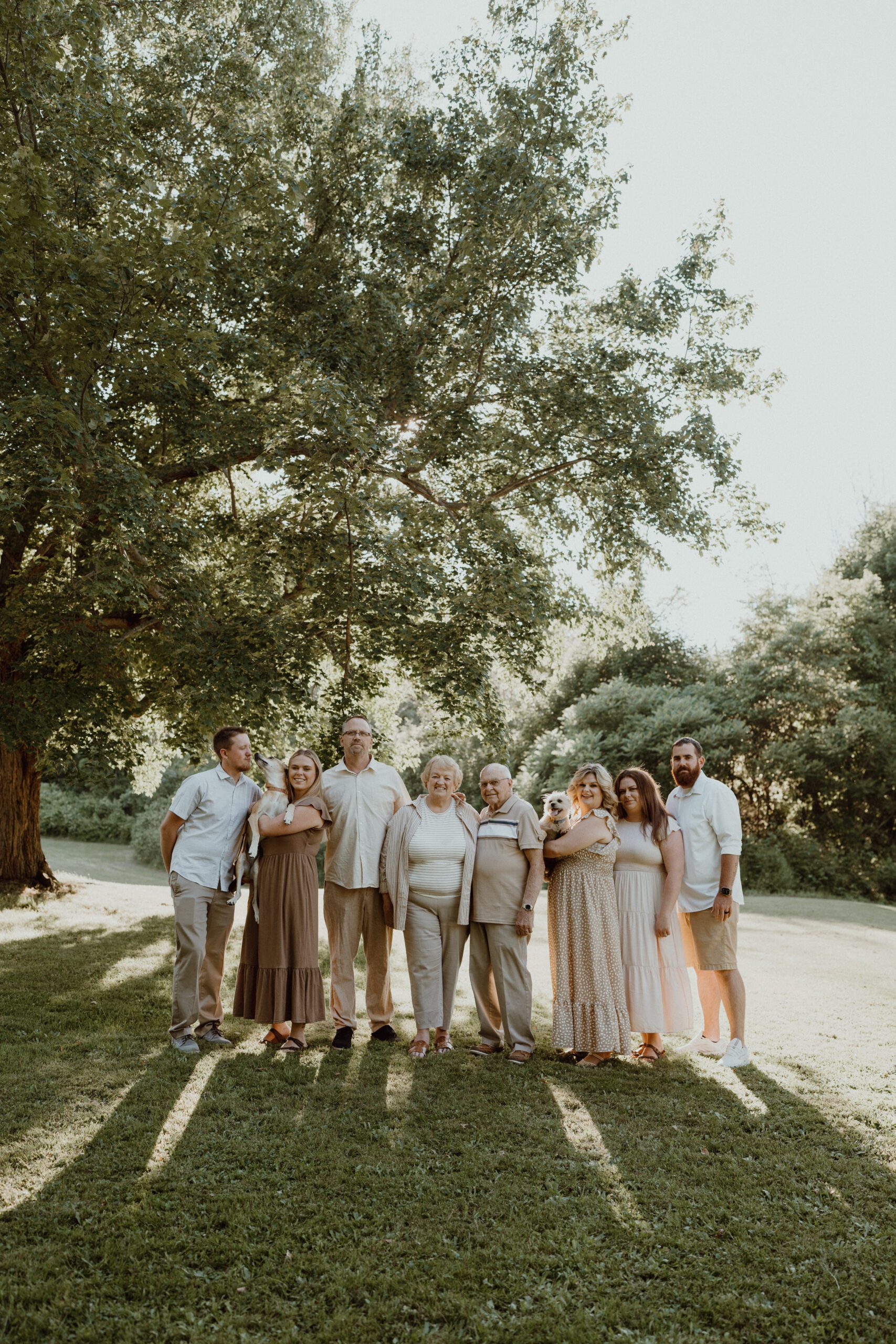 “Siblings and spouses laughing together in a candid outdoor portrait.”